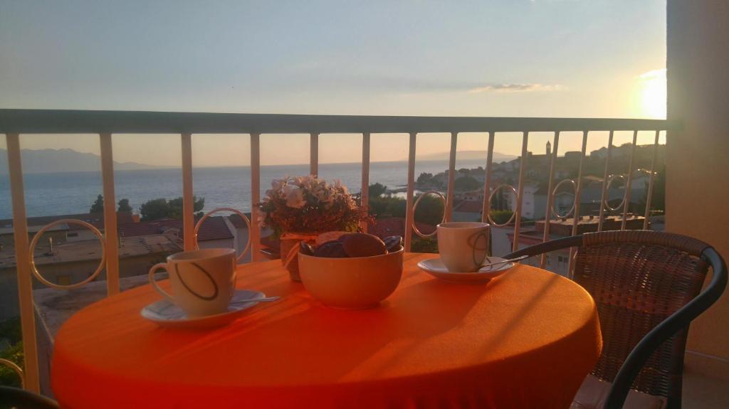 una mesa con tazas y platillos en el balcón en Apartments Roncevic #JOKO#, en Gradac