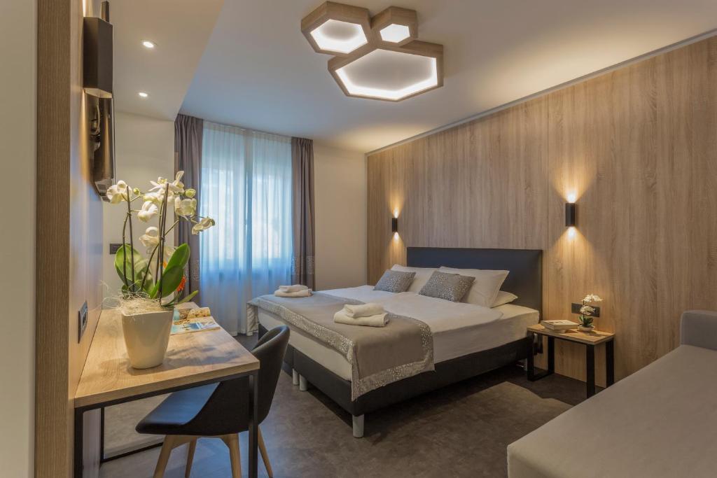 ein Hotelzimmer mit einem Bett, einem Tisch und einem Schreibtisch in der Unterkunft Tourist Hotel in Brixen