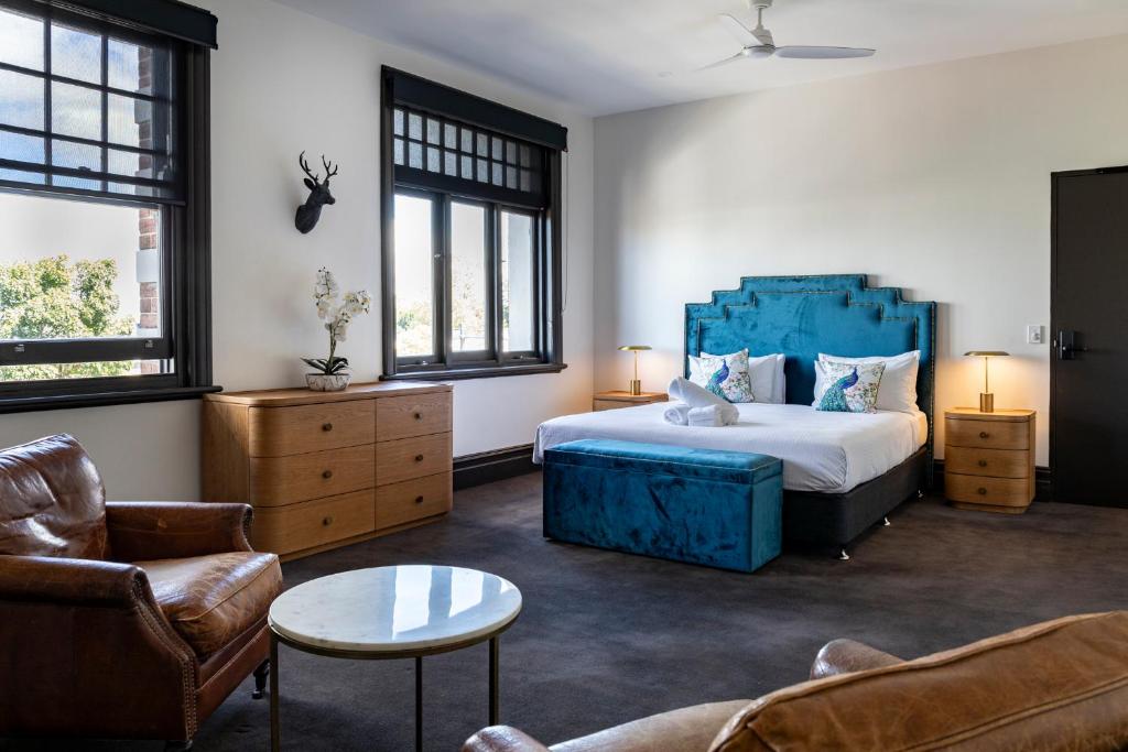a bedroom with a bed and a couch and a table at Imperial Hotel Paddington in Sydney