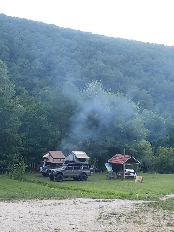 a truck parked in a field next to a mountain at Kamp Suad in Zaglavica
