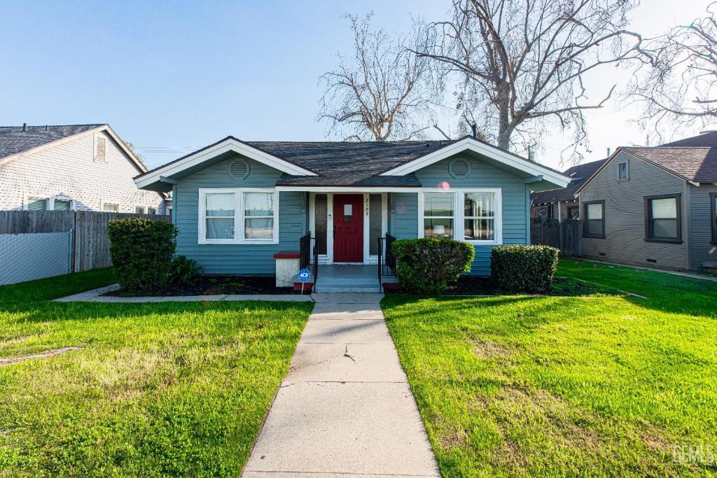 a blue house with a red door in a yard at Luxury Stay Near Downtown Bakersfield in Bakersfield