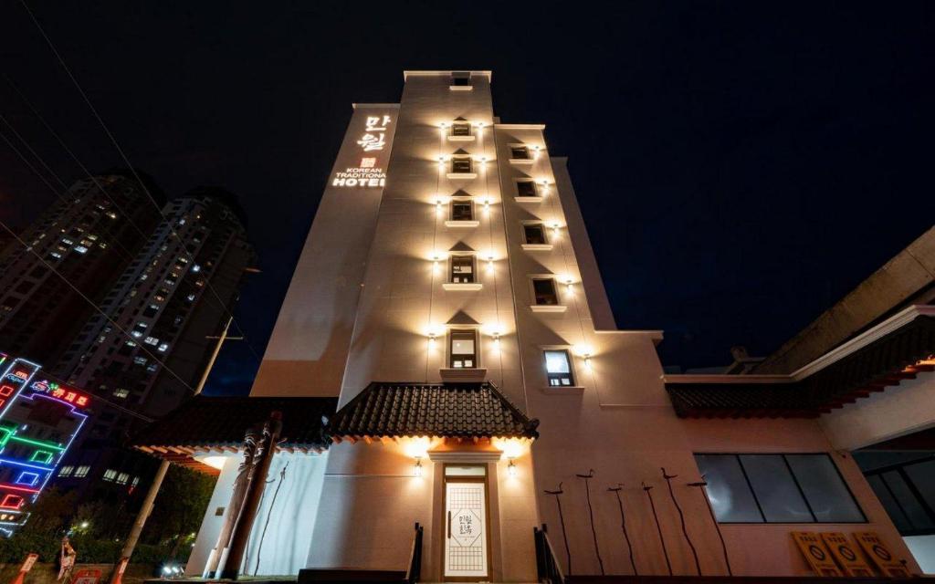 a tall building with lights on it at night at Manwol Hotel Yuseong in Daejeon