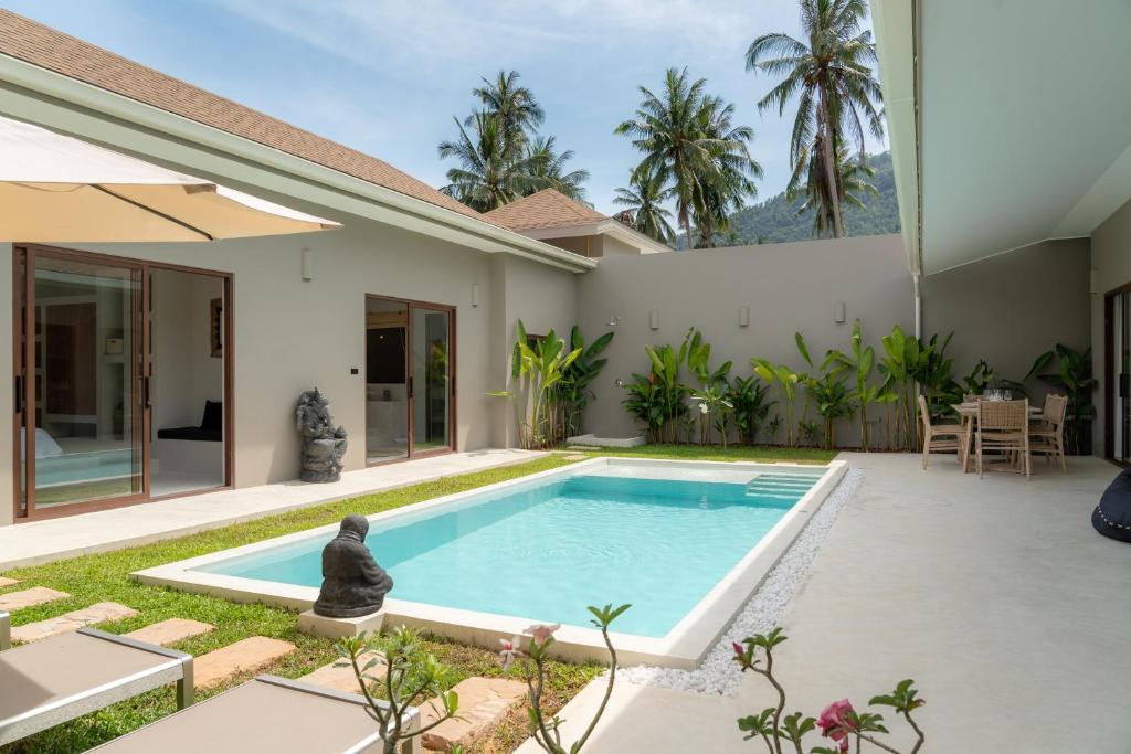 a swimming pool in the backyard of a house at Karma Shana Residence in Lamai
