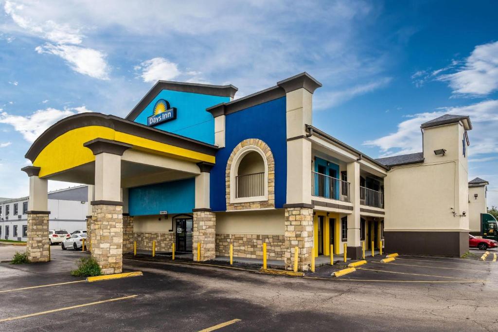 a blue and yellow building with a parking lot at Days Inn by Wyndham Houston East in Houston