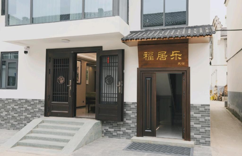 a building with two doors and a sign on it at 福居乐 in Caodian