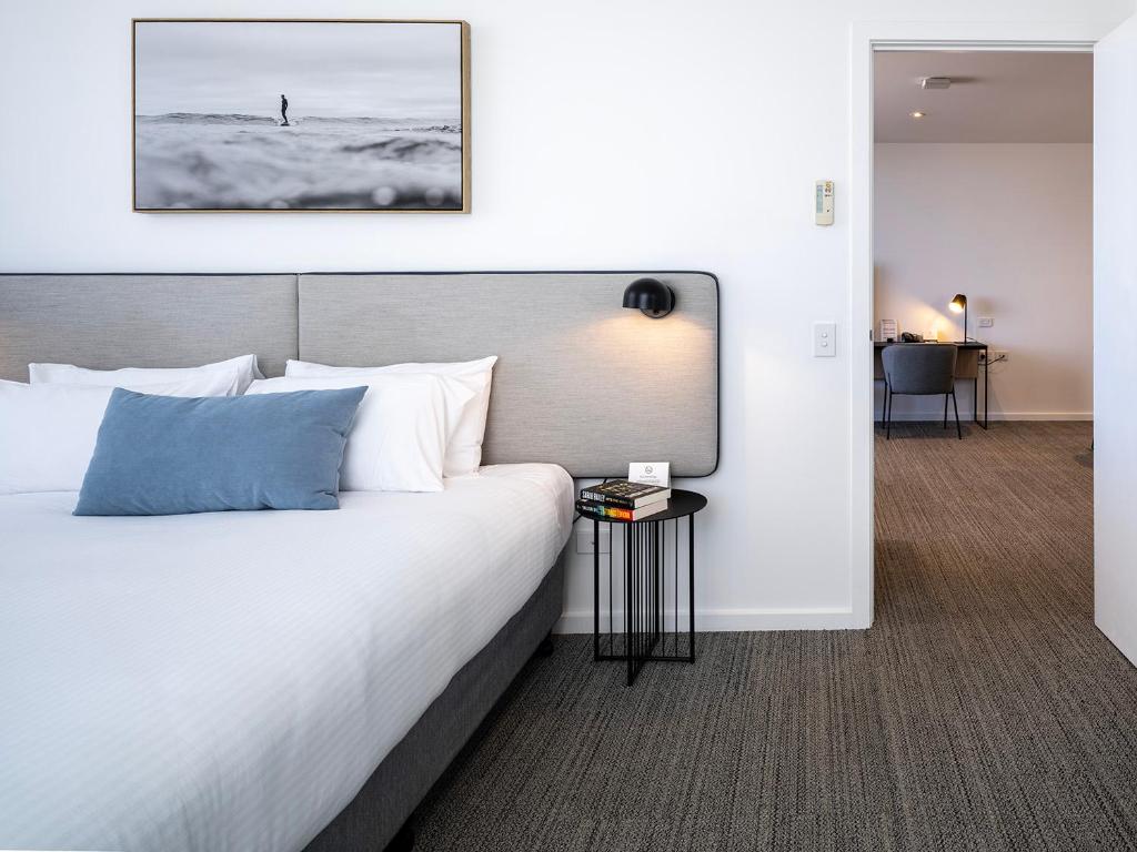 a bedroom with a large white bed in a room at Quest Robina in Gold Coast