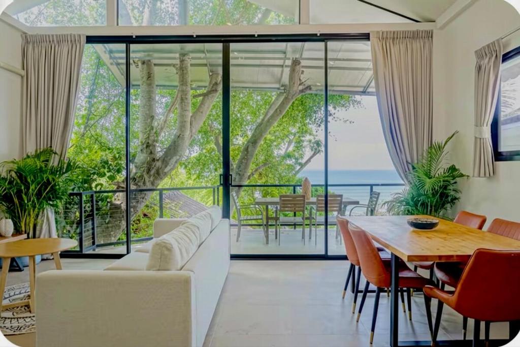 a living room with a white couch and a table and chairs at v27 Sunset Horizon Villa Seaview in Haad Yao