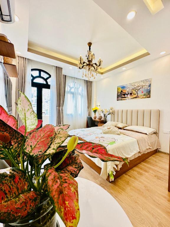 a bedroom with a bed and a table with a plant at Myla House in Ho Chi Minh City