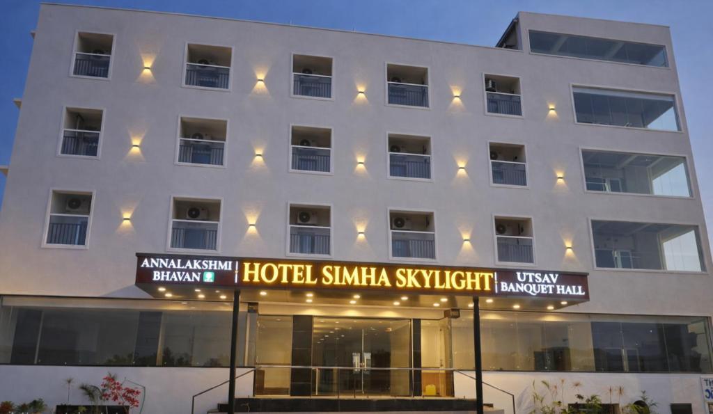 ein weißes Gebäude mit einem Hotel Sirma Sagittilli in der Unterkunft Hotel Simha Skylight - Tirupati in Tirupati