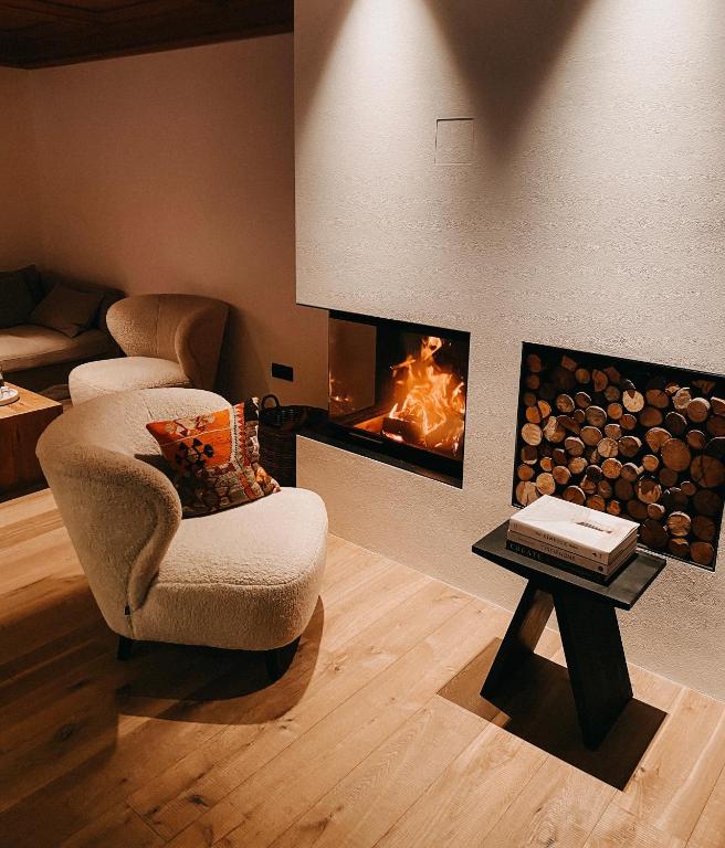 a living room with a chair and a fire place at Mountain Chalet Pra Ronch in Selva di Val Gardena