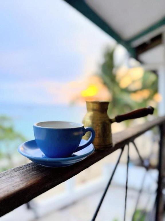 a blue coffee cup sitting on a wooden table at The Archipelago Waterfront in Zanzibar City