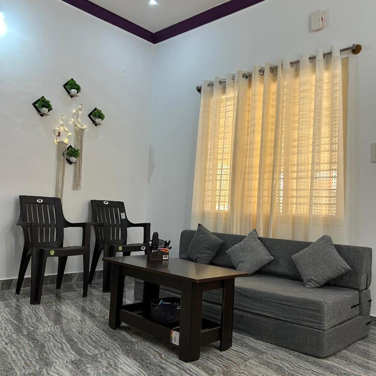 a living room with a couch and two chairs and a table at Simba Stay's 2BHK in Chikmagalūr