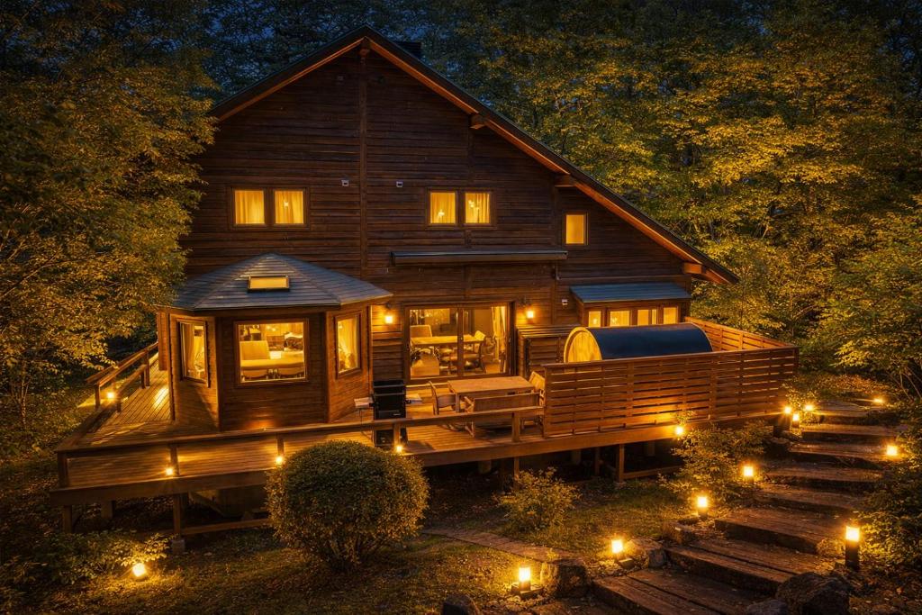 a large wooden house with lights in front of it at 那須グランドロッジ,サウナ,カラオケ,屋根付BBq in Nasu