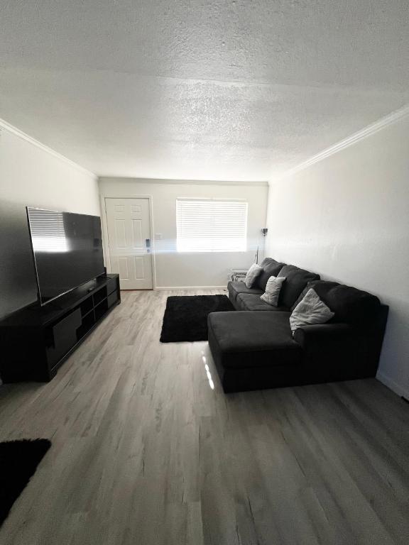 a living room with a black couch and a flat screen tv at Renovated Downtown Phoenix Condo in Phoenix