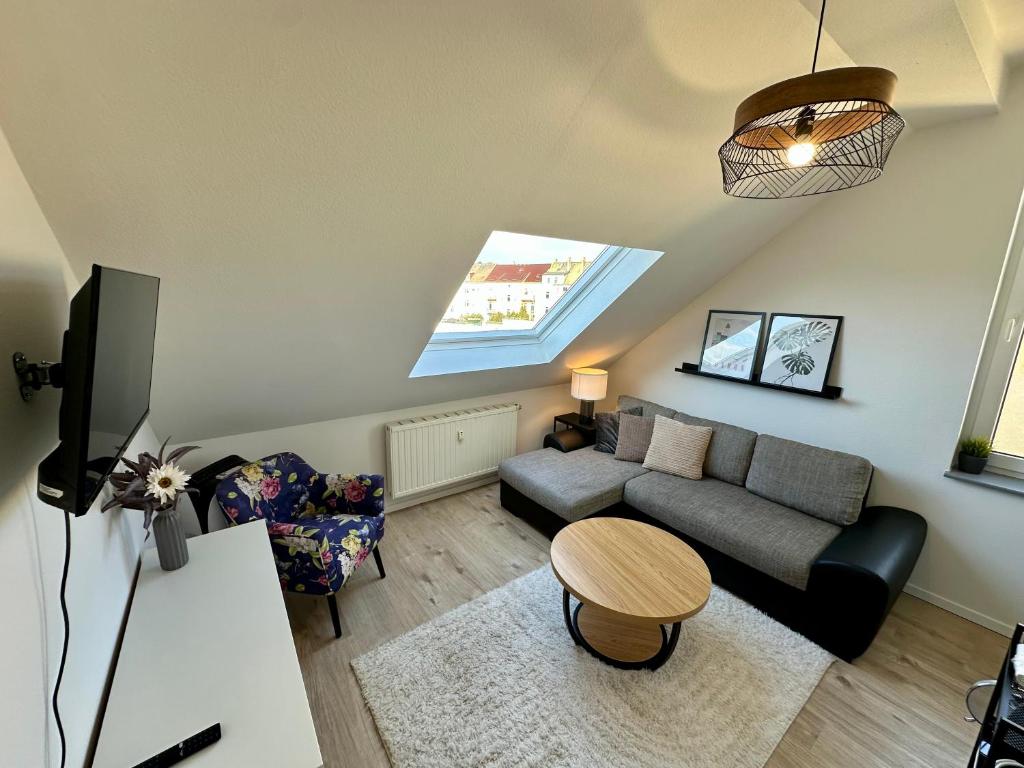a living room with a couch and a table at Gästeapartment Schkeuditz Dachgeschoss in Schkeuditz