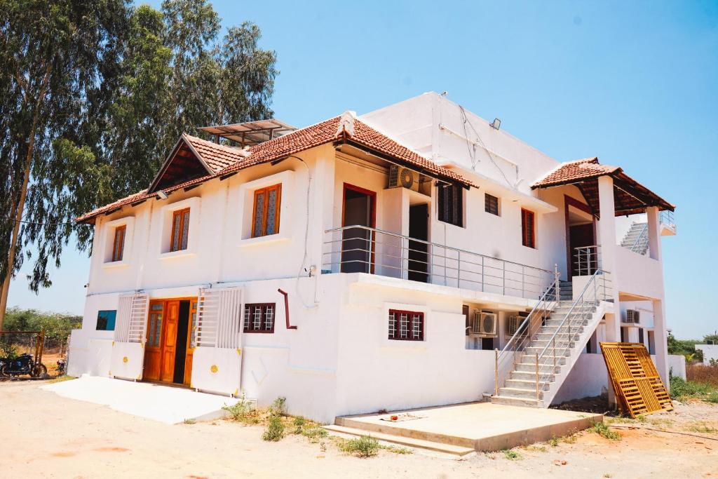 a white house with a staircase in front of it at Sumiwhitehouse in Vallam