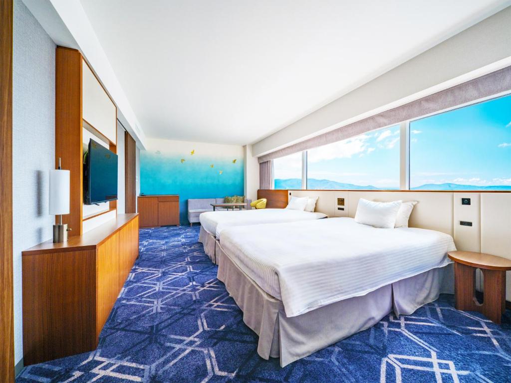a hotel room with a large bed and a large window at Hotel Nikko Himeji in Himeji