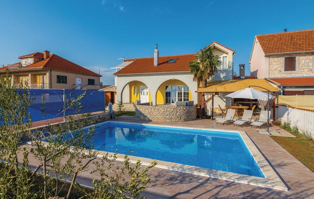 a swimming pool in front of a house at Holiday Home Sunce Dalmacije in Mratovo