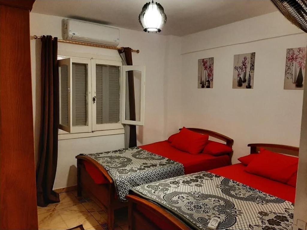 a bedroom with two beds and a window at شالية بقرية ريم الفلا in Dawwār Shindī Fannūsh