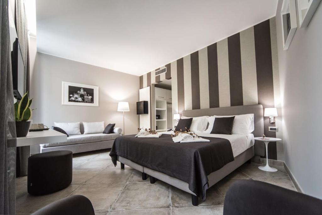 una camera con un grande letto e una parete a righe di ETNEA 454 Catania Luxury Rooms a Catania
