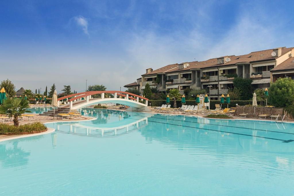 a large pool of blue water in a resort at Calm House in Desenzano del Garda