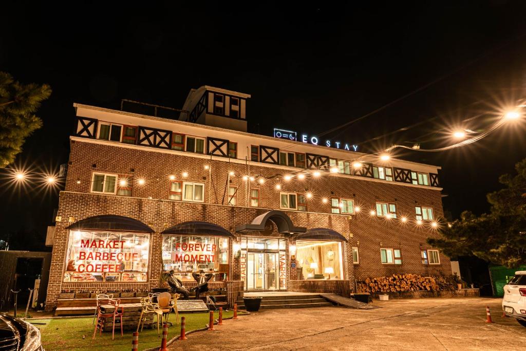 a large brick building with lights on it at night at Jeju EQ Stay Hotel in Jeju