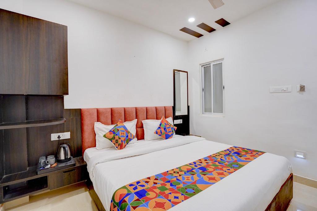 a bedroom with a large bed with colorful pillows at FabHotel Swastik Villa in Varanasi