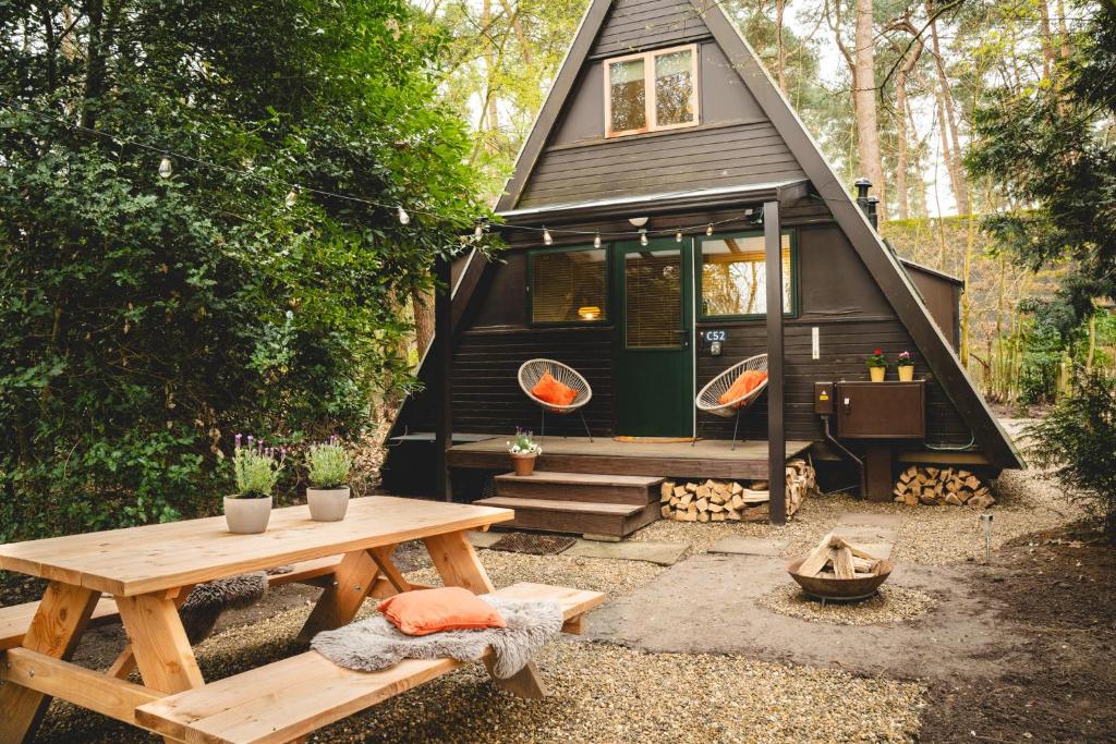 a black tiny house with a picnic table in front of it at Boshuisje Rekem - Nirvana in Lanaken