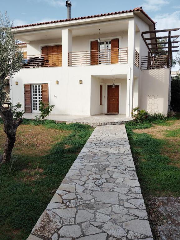 a white house with a walkway in front of it at Leo House in Selínia