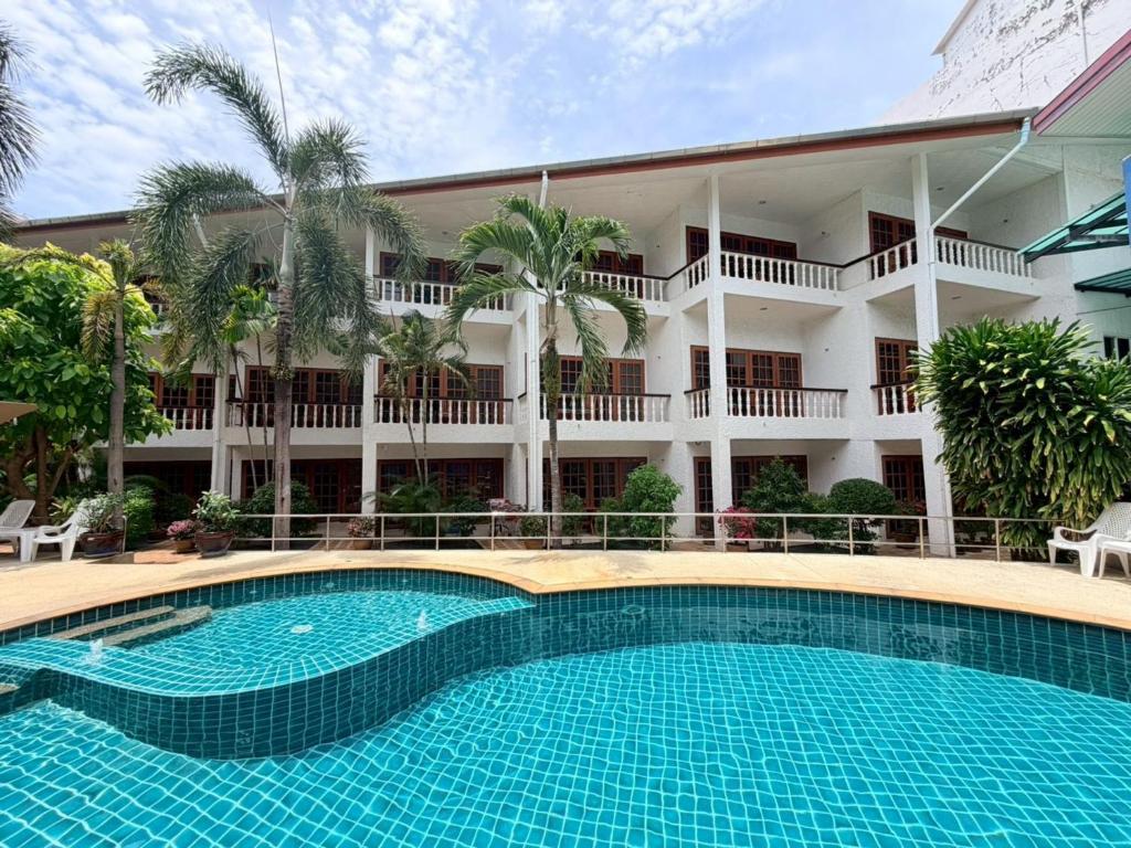 a swimming pool in front of a building at Blue Neptuna Hotel Patong in Patong Beach