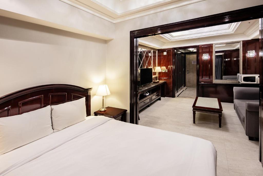 a bedroom with a bed and a living room at Gangnam Artnouveau City in Seoul