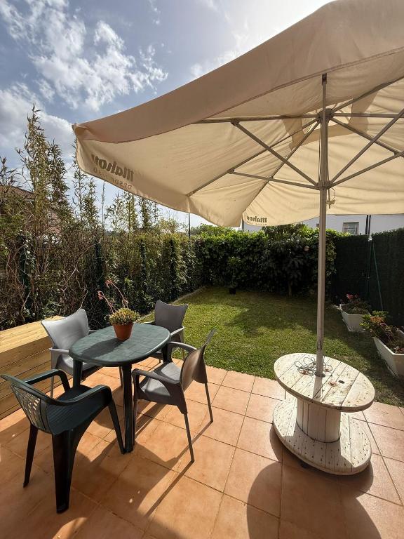 a patio with an umbrella and a table and chairs at El Rincón de Usgo in Miengo