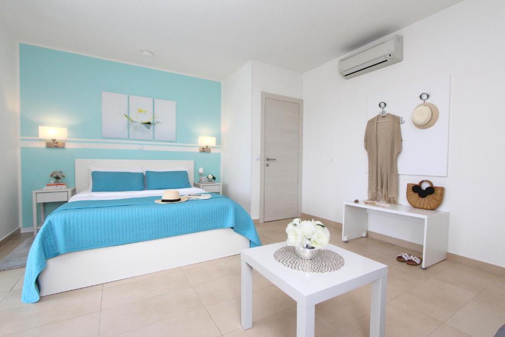 a blue and white bedroom with a bed and a table at Studio Emanuel in Rovinj