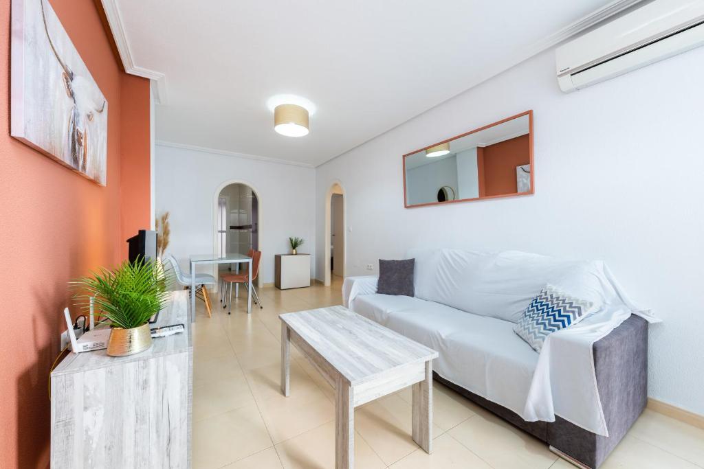 a living room with a white couch and a table at Playa del Pinet 2 in La Marina
