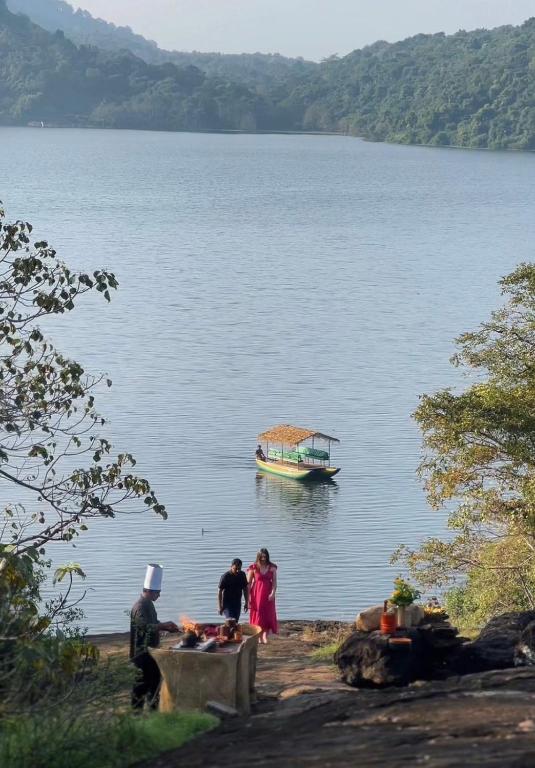 a group of people standing on a lake with a boat at Kevans Casa in Mahiyangana