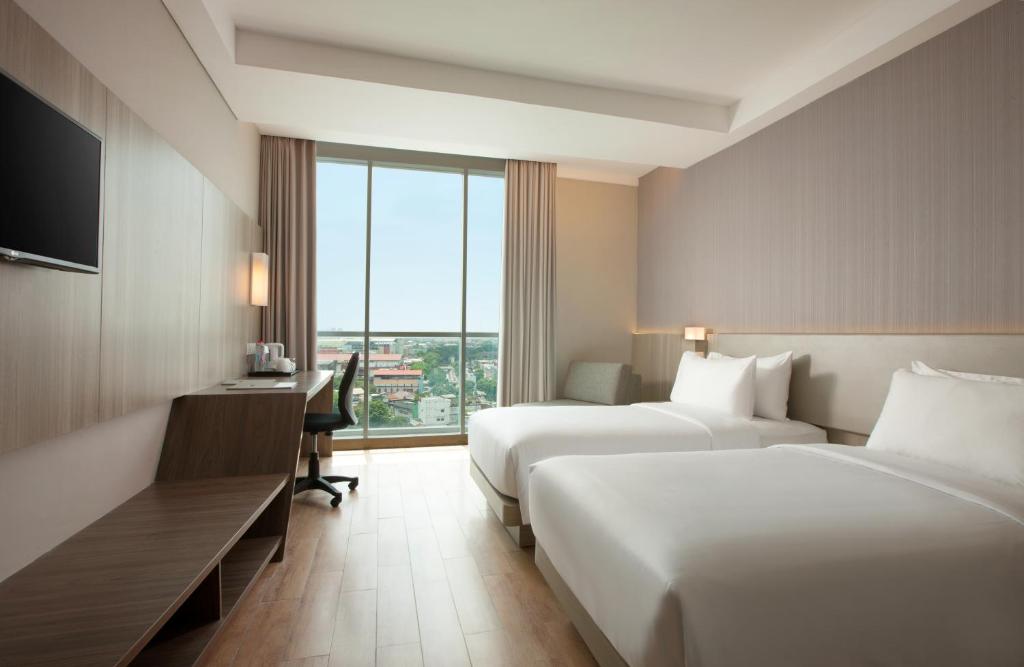 Postel nebo postele na pokoji v ubytování Hotel Santika Radial Palembang