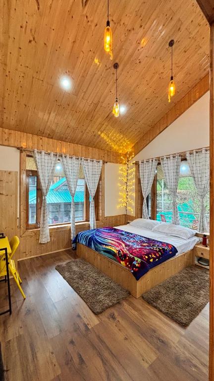 a bedroom with a large bed in a room with windows at Akari Inn in Haripūr