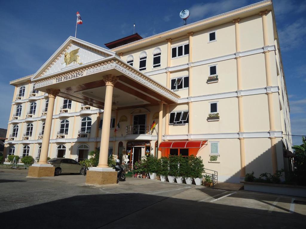 um grande edifício branco com uma bandeira em cima em Phadaeng Hotel em Ubon Ratchathani