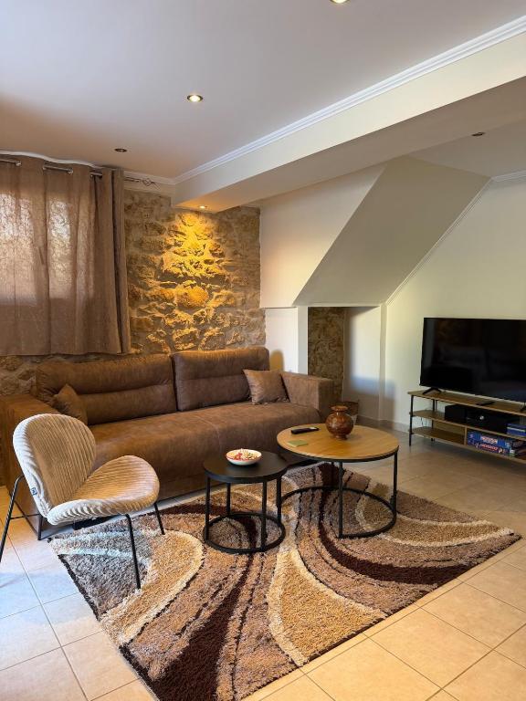 a living room with a couch and a tv at To Petrino apartment in Kyparissia