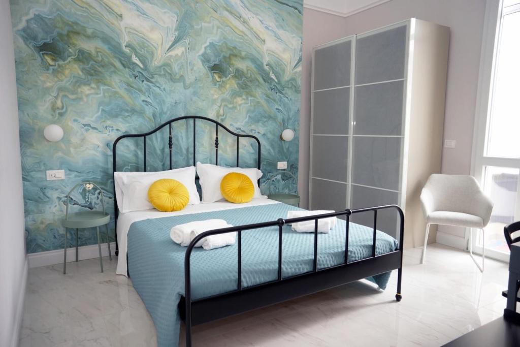 a bedroom with a bed with a painting on the wall at Luxury Suite ATHENA - MINERVA in Reggio di Calabria