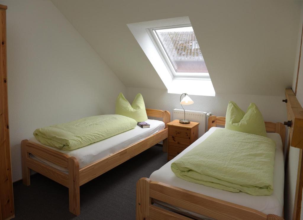 two twin beds in a room with a window at Lindenhof Helmke in Schellerten