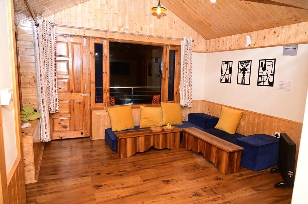 a living room with a blue couch and yellow pillows at Romantic loft with mountain view in manali in Haripūr