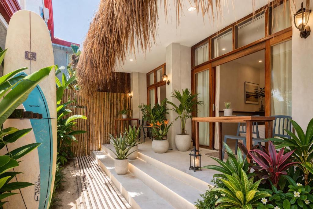 a patio with plants and a table and a surfboard at Gratitude Inn in General Luna