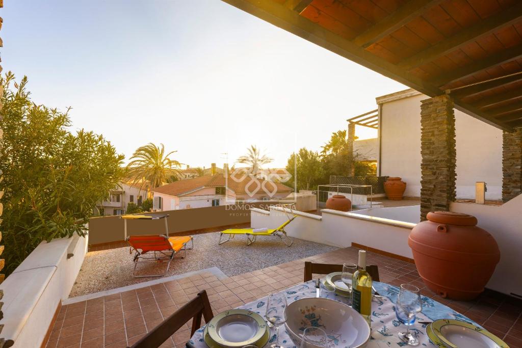 a patio with a table and chairs on a roof at Villino Joy in Stintino