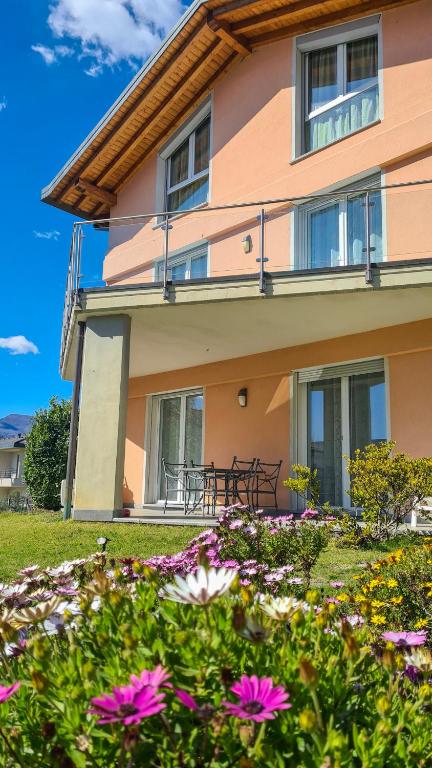 a house with a table and flowers in the yard at Casa Belfiore in Maccagno Superiore