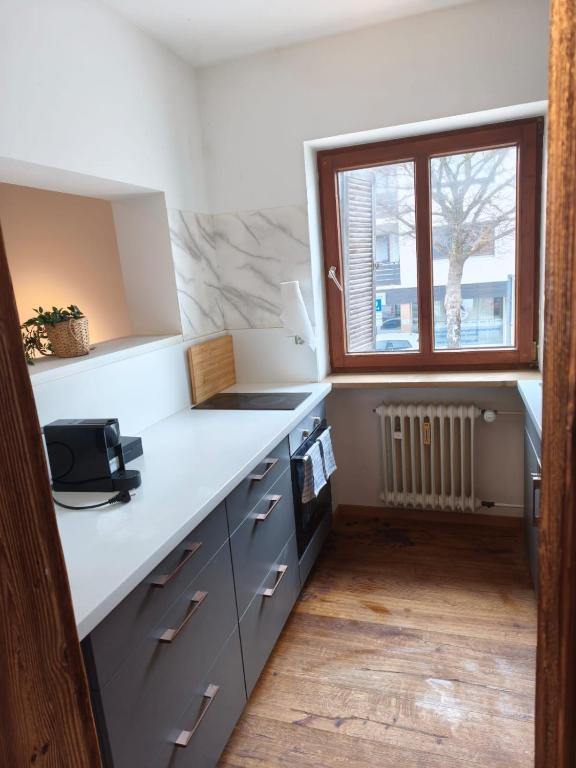 a kitchen with a white counter and a window at Apartment King Louie in Prien am Chiemsee