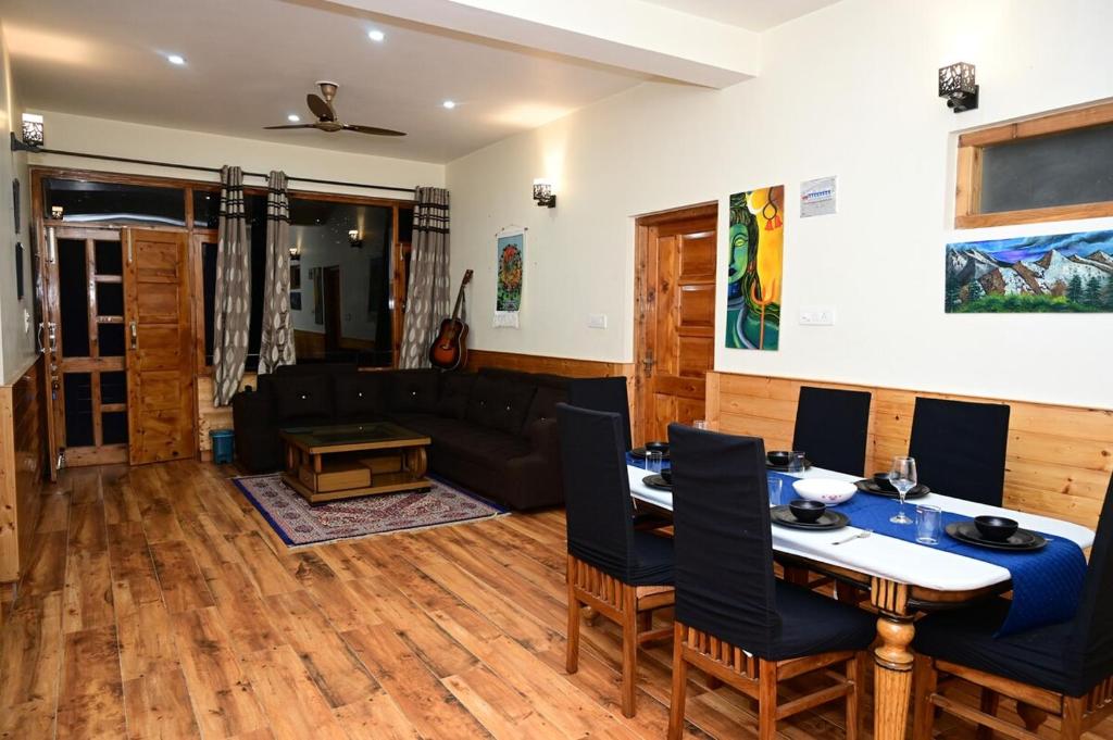a living room with a table and a couch at Akari Inn in Haripūr