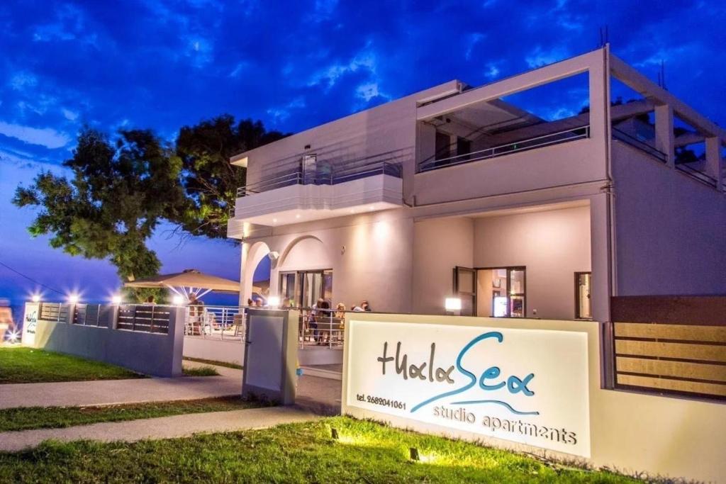 a white house with a sign in front of it at ThalaSea Studio - Apartments in Mytikas