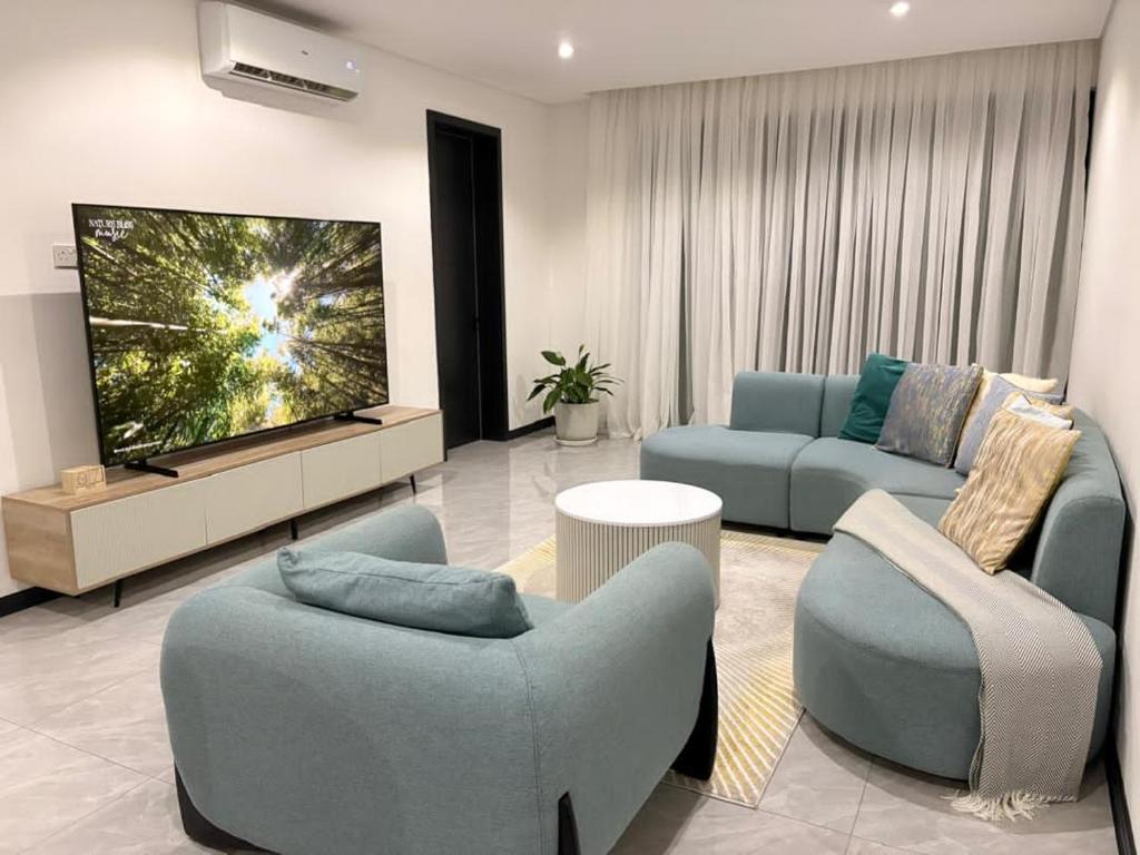 a living room with two couches and a flat screen tv at Blue Diamond Luxe in Gaborone