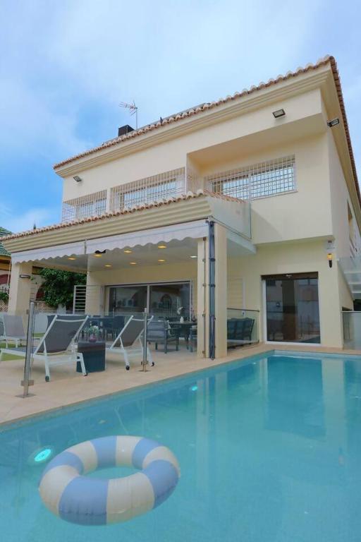 a swimming pool in front of a house at August Villa Málaga. Relax Playa Piscina Coworking in Málaga